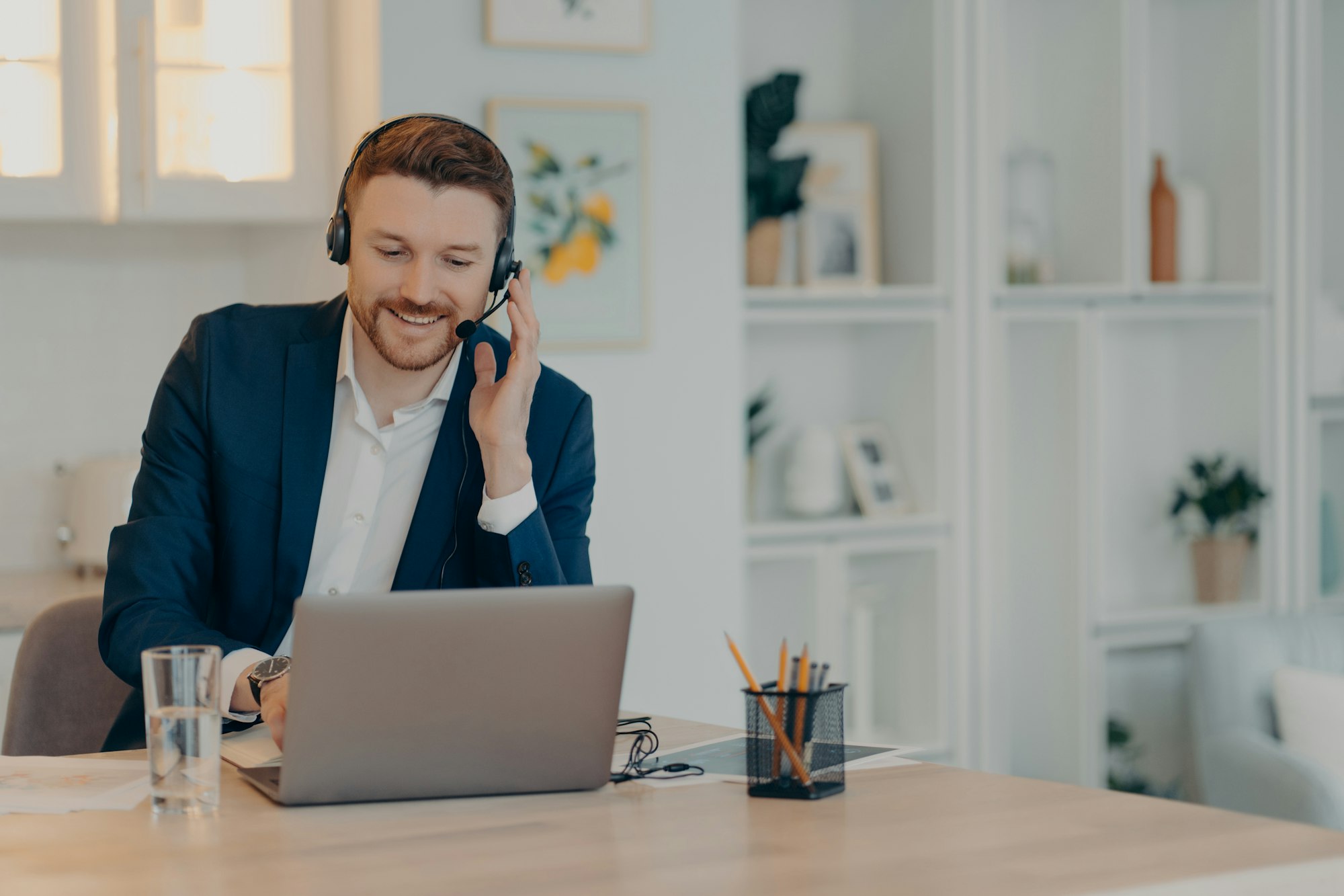 Young male freelancer working remotely from home and using laptop