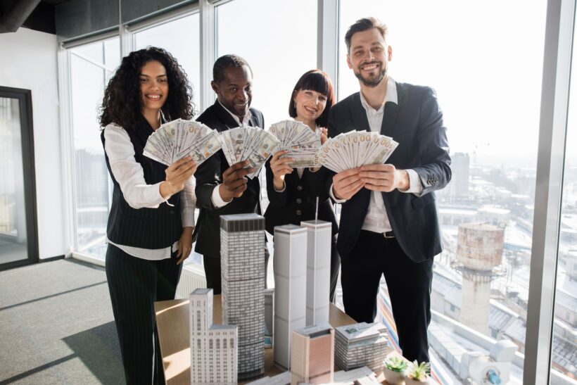 Team of diverse multiethnic business people holding bundle of american dollar cash money