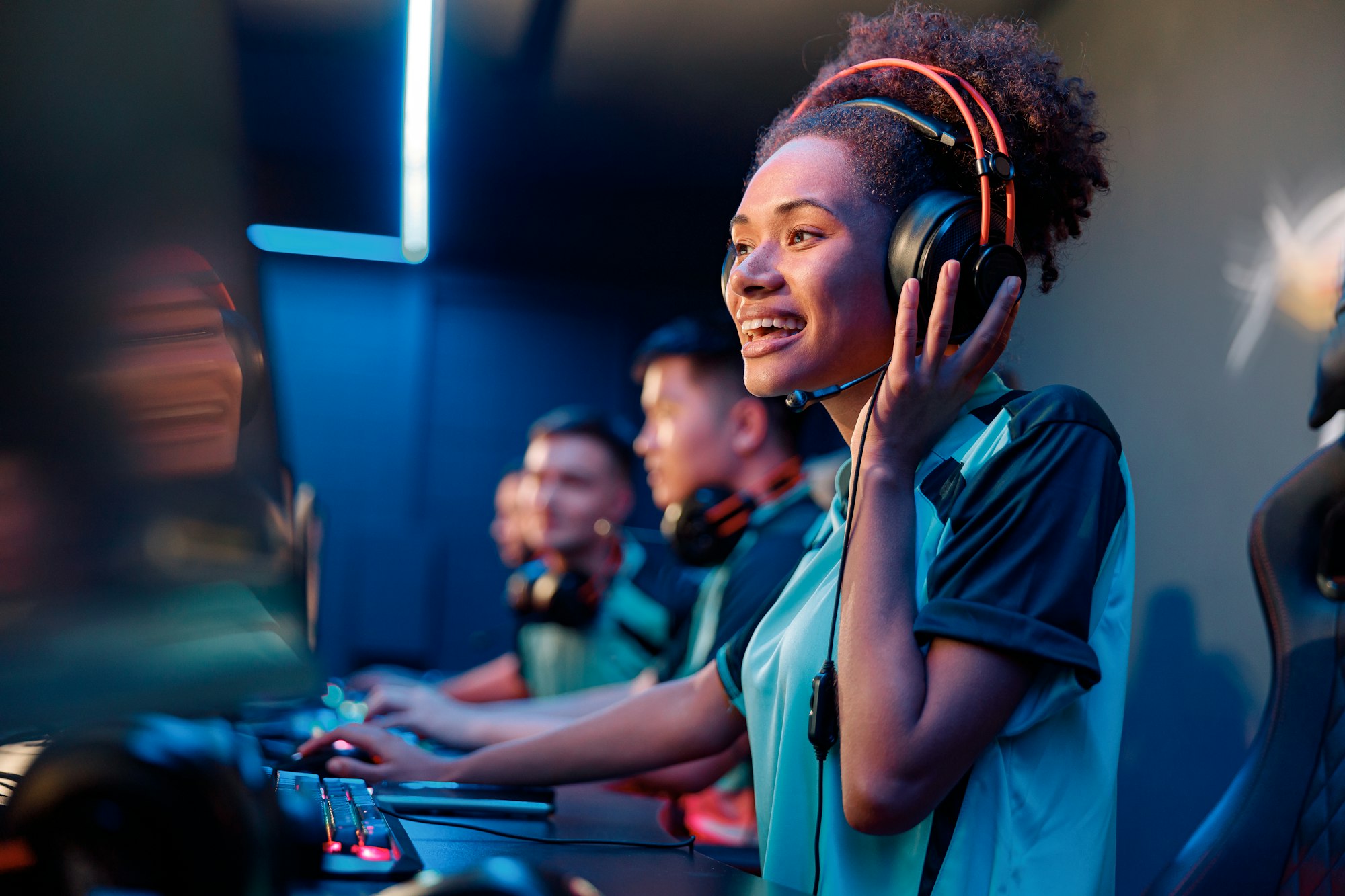 Young woman in headphones plays computer game in internet club